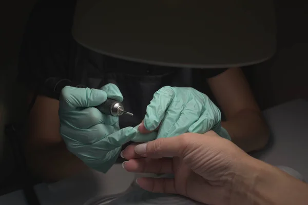 Vrouw handen ontvangen een manicure in schoonheidssalon. Nagelvijl. Close-up, selectieve focus. — Stockfoto