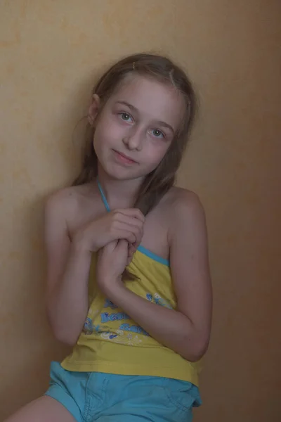 Kleines blondes Mädchen in gelbem T-Shirt, lächelnd auf hellem Hintergrund, Platz für Text — Stockfoto