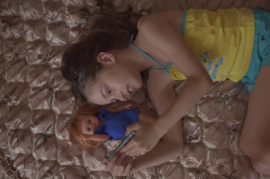 Güzel genç kadın bir akıllı telefon kullanarak ve yatakta yatan gülümseyen bir selfie yapıyor