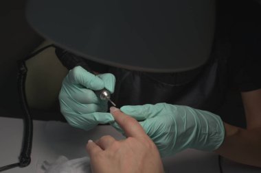 Kadın elleri güzellik salonunda manikür yaptırıyor. Tırnak törpüleme. Yaklaş, seçici odaklanma.