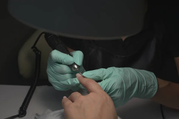 Vrouw handen ontvangen een manicure in schoonheidssalon. Nagelvijl. Close-up, selectieve focus. — Stockfoto