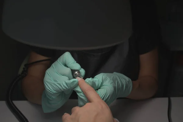 Vrouw handen ontvangen een manicure in schoonheidssalon. Nagelvijl. Close-up, selectieve focus. — Stockfoto