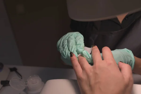 Vrouw handen ontvangen een manicure in schoonheidssalon. Nagelvijl. Close-up, selectieve focus. — Stockfoto