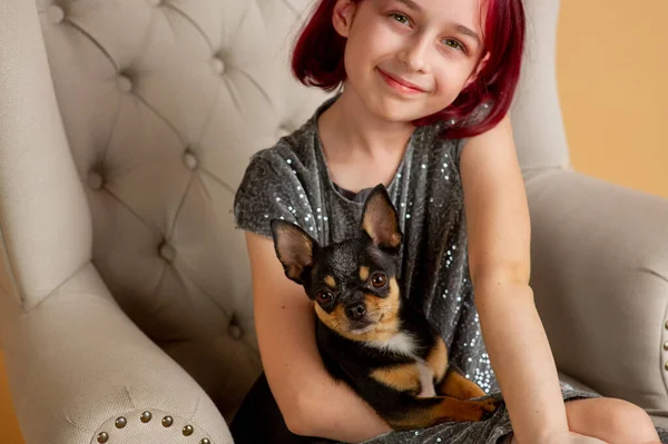 Nastolatka dziewczyna z jej ulubionym psem to Chihuahua siedzi na kanapie — Zdjęcie stockowe