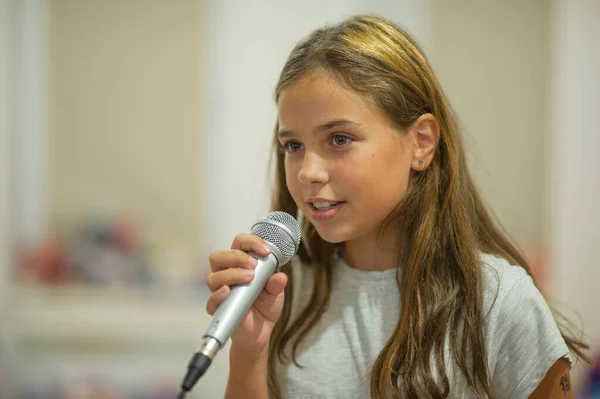 Young girl with microphone on white background — Stock Photo, Image