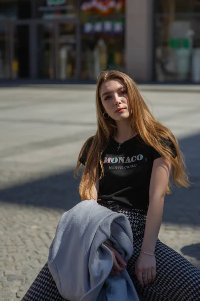 검은 티셔츠와 회색 바지를 입은 소녀 가 거리에서 사진을 찍는다. 도시의 산속을 걷는 아름다운 여인 — 스톡 사진