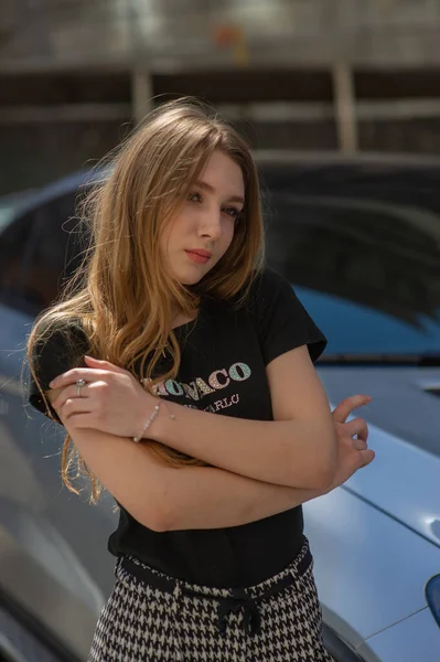 Una giovane ragazza con una maglietta nera e pantaloni grigi è fotografata per strada. Bella donna in una passeggiata in città — Foto Stock