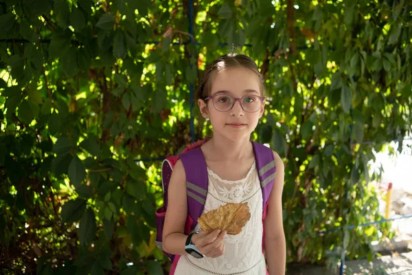 Школьница с фиолетовым рюкзаком и фиолетовыми очками. Девушка в белом платье, в очках осенью . — стоковое фото