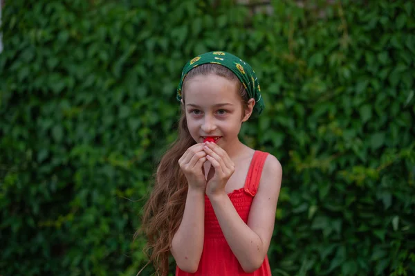 Menina na rua contra um fundo de folhagem verde. Menina com cabelo comprido. Criança 9-10 anos — Fotografia de Stock