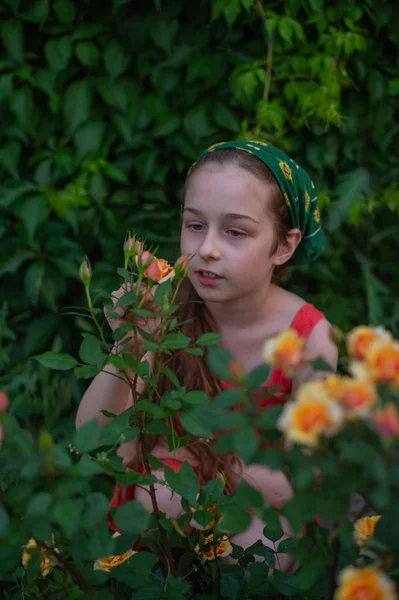 Petite fille dans la rue sur fond de feuillage vert. Une fille aux cheveux longs. Enfant 9-10 ans — Photo