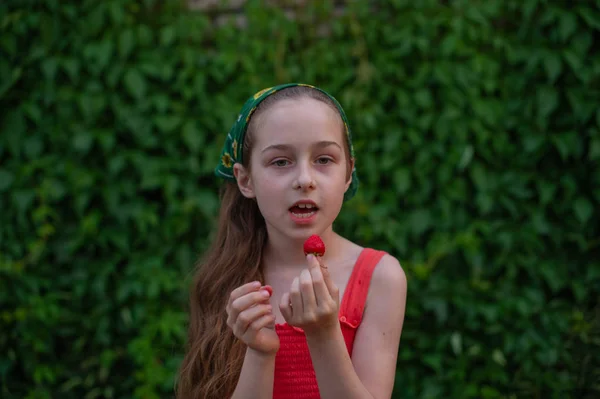 Little girl on the street against a background of green foliage. Girl with long hair. Child 9-10 years old — 스톡 사진