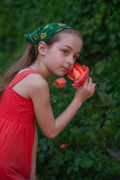 Sokaktaki küçük kız yeşil yapraklı bir arka plana karşı. Uzun saçlı kız. Çocuk 9-10 yaşlarında. — Stok fotoğraf