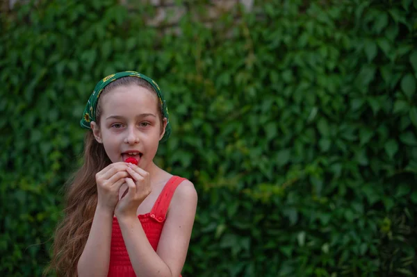 Little girl on the street against a background of green foliage. Girl with long hair. Child 9-10 years old — 스톡 사진