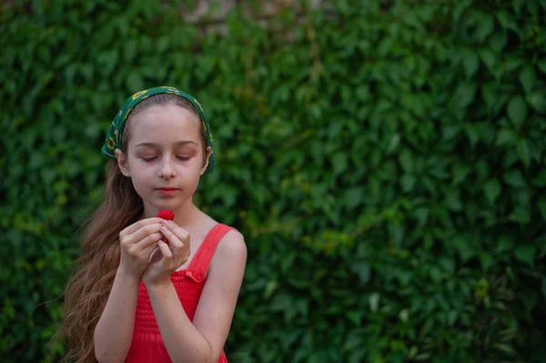 Liten flicka på gatan mot en bakgrund av grönt lövverk. Flicka med långt hår. Barn 9-10 år — Stockfoto