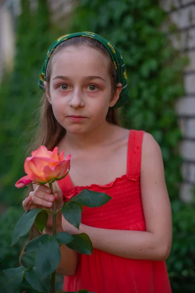 Petite fille dans la rue sur fond de feuillage vert. Une fille aux cheveux longs. Enfant 9-10 ans — Photo