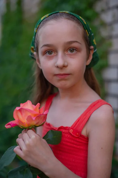 Sokaktaki küçük kız yeşil yapraklı bir arka plana karşı. Uzun saçlı kız. Çocuk 9-10 yaşlarında. — Stok fotoğraf