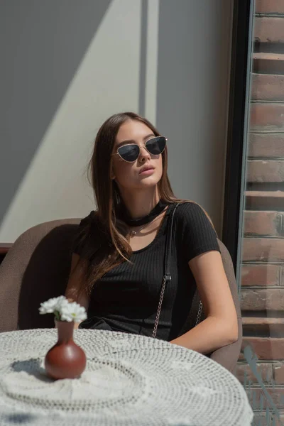 Mulher elegante em um café. Senhora sentada numa cadeira. Menina de óculos — Fotografia de Stock