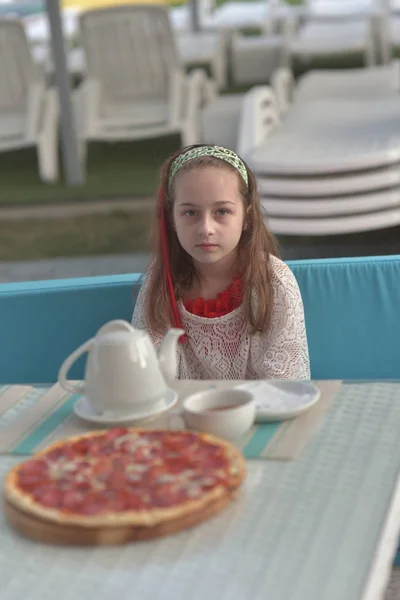 カフェでピザと若い女性の肖像画。女の子9歳食べるピザで夏のカフェの休暇 — ストック写真