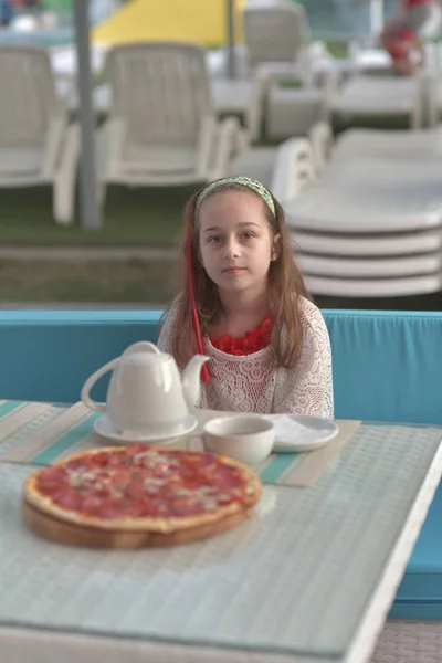 Портрет молодої жінки з піцою в кафе. Дівчинка 9 років їсть піцу в літньому кафе у відпустці — стокове фото