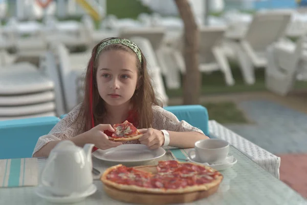 Retrato de mujer joven con pizza en la cafetería. Chica de 9 años come pizza en un café de verano de vacaciones — Foto de Stock