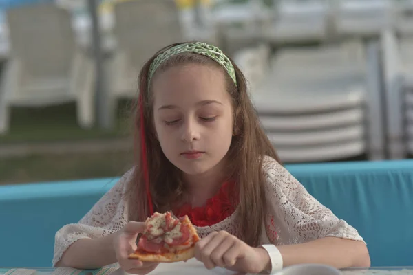 Retrato de jovem com pizza no café. Menina 9 anos de idade come pizza em um café de verão em férias — Fotografia de Stock