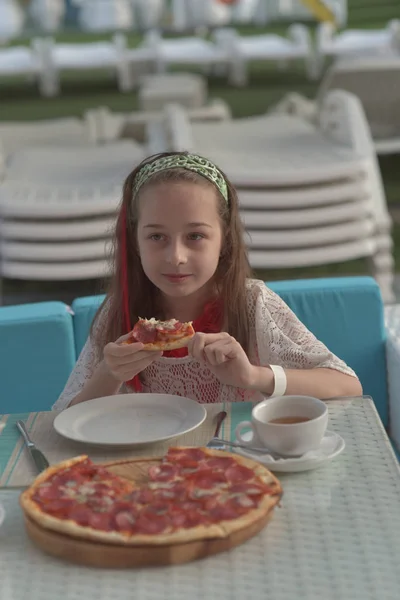 Retrato de jovem com pizza no café. Menina 9 anos de idade come pizza em um café de verão em férias — Fotografia de Stock