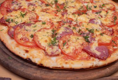 Taze pişmiş pizzanın en üst görüntüsü. Tahta tabakta pizza.