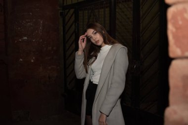 Gece şehrinde ceketli hoş bir kızın portresi. Esmer kız ve gece şehri.