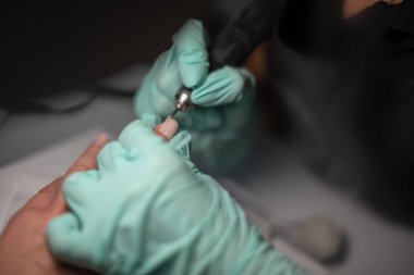 Bir çivi ile manikür el mavi hijyenik eldiven bir manikür el yatıyor.