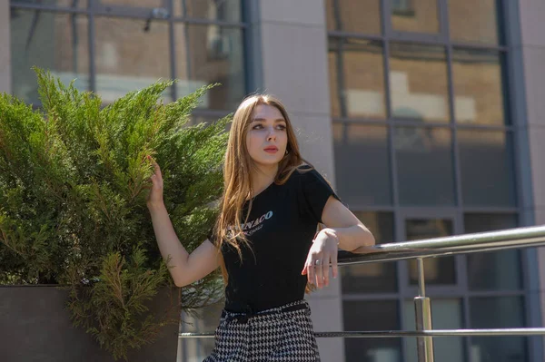 Glamour giovane donna indossa abito alla moda in posa con i capelli svolazzanti al muro grigio — Foto Stock