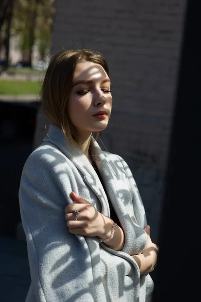 La chica guapa la rubia. Hermosa chica posando para dar un paseo. Chica de fútbol negro y un abrigo gris . — Foto de Stock