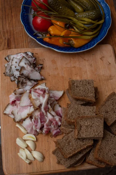 Бекон, хліб і огірок на дерев'яному фоні. Російська та Українська традиційна закуска — стокове фото