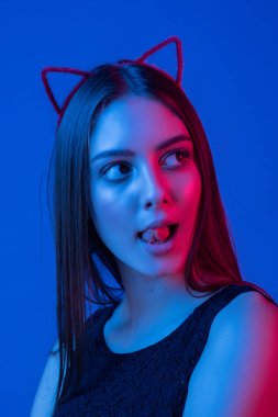 Renkli parlak ışıklarıyla stüdyoda poz veren yüksek model kadın. Makyajlı güzel seksi bir kızın portresi..