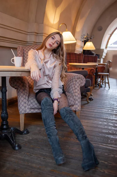 Μια νεαρή όμορφη γυναίκα στο καφέ. Γκραντζ. Κορίτσι σε καφέ με μπεζ μπλούζα. Ένα κορίτσι πίνει καφέ σε ένα καφέ. Λάτε, καπουτσίνο — Φωτογραφία Αρχείου