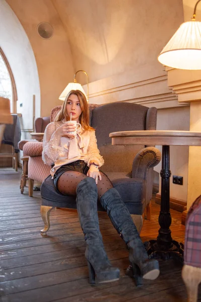Jeune jolie femme au café. Grunge. Une fille dans un café en chemisier beige. Une fille boit du café dans un café. Latte, Cappuccino — Photo