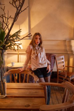 Kafedeki genç ve güzel kadın. Grunge. Kafede bej bluzlu bir kız.