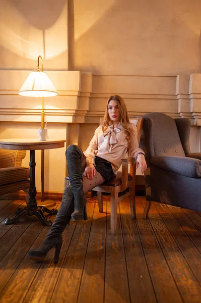 Una joven y bonita mujer en la cafetería. Grunge. Chica en un café en una blusa beige — Foto de Stock