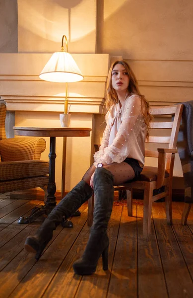 Una joven y bonita mujer en la cafetería. Grunge. Chica en un café en una blusa beige — Foto de Stock