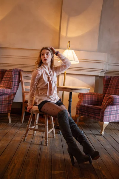 Jonge mooie vrouw in café. Grunge. Meisje in een cafe in een beige blouse — Stockfoto