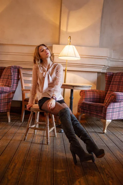 Una joven y bonita mujer en la cafetería. Grunge. Chica en un café en una blusa beige — Foto de Stock