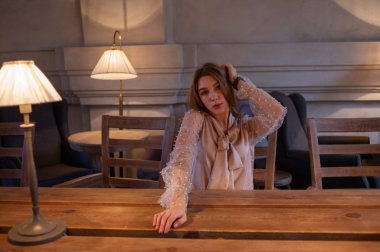 Kafedeki genç ve güzel kadın. Grunge. Kafede bej bluzlu bir kız.