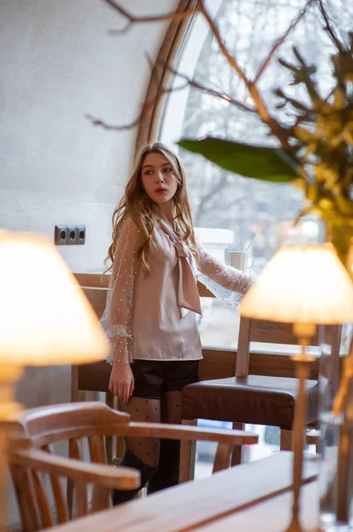 Jeune jolie femme au café. Grunge. Fille dans un café dans un chemisier beige — Photo
