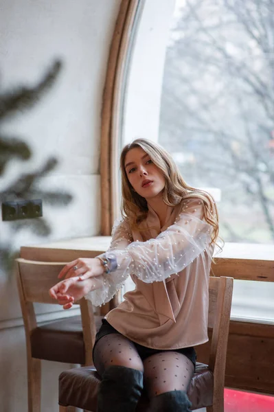 Jeune jolie femme au café. Grunge. Fille dans un café dans un chemisier beige — Photo