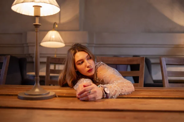 Young pretty woman in cafe. grunge. Girl in a cafe in a beige blouse — Stock Photo, Image