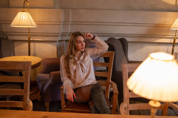 Jeune jolie femme au café. Grunge. Fille dans un café dans un chemisier beige — Photo