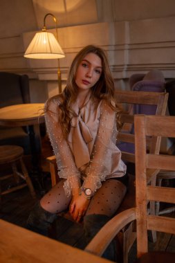 Kafedeki genç ve güzel kadın. Grunge. Kafede bej bluzlu bir kız.