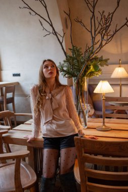 Kafedeki genç ve güzel kadın. Grunge. Kafede bej bluzlu bir kız.