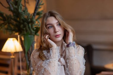 Kafedeki genç ve güzel kadın. Grunge. Kafede bej bluzlu bir kız.