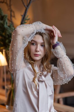 Kafedeki genç ve güzel kadın. Grunge. Kafede bej bluzlu bir kız.