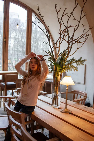 Jeune jolie femme au café. Grunge. Fille dans un café dans un chemisier beige — Photo